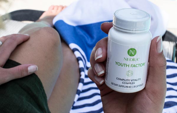 Lifestyle shot of a person holding a bottle of Youth Factor® Complete Vitality Complex.